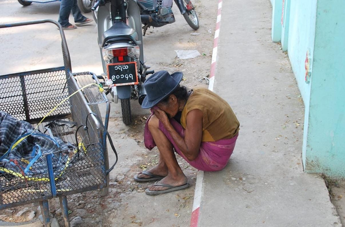 Imagen de un propietario reparando una tubería bajo el fregadero en una cocina moderna en España